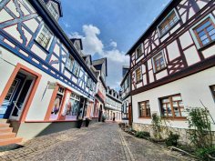 In der Eltviller Altstadt gibt es zahlreiche Fachwerkbauten zu bestaunen. Eine Straße mit Fachwerkhäusern und Kopfsteinflaster in der Eltviller Altstadt.