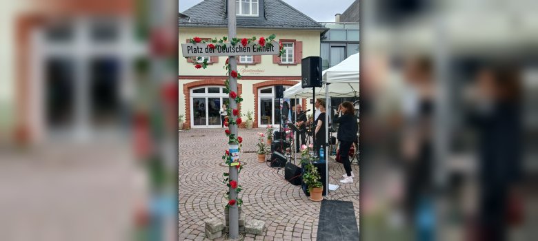Eine Musikband, ein Schild "Platz der Deutschen Einheit", Blick auf die Mediathek